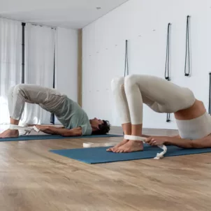 Man and woman doing bridge pose to strengthen pelvic floor muscles